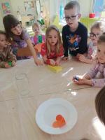 Grupa dzieci bawi się i eksperymentuje w przedszkolu.