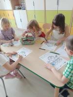 Grupa dzieci bawi się i eksperymentuje w przedszkolu.